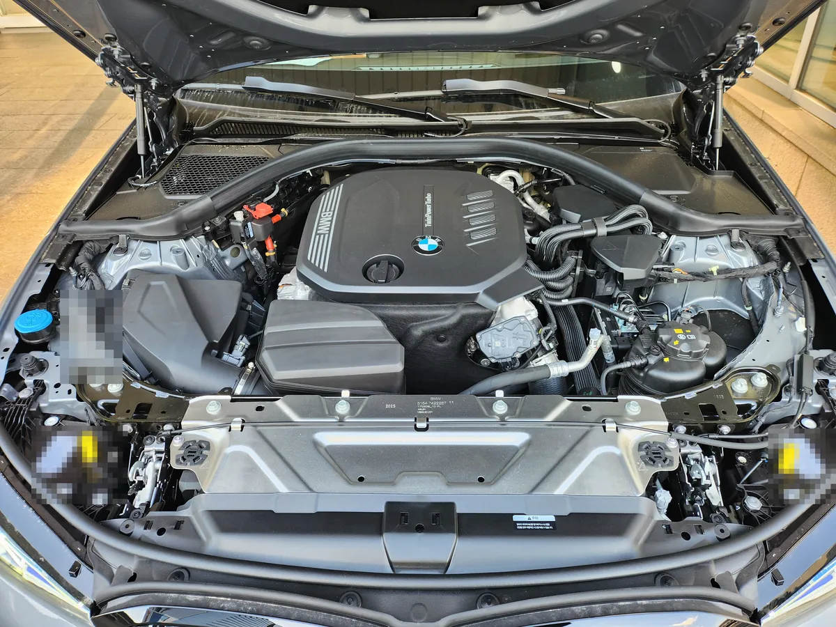 보닛을 연 BMW 320d 엔진룸 — 엔진 커버와 주변 부품