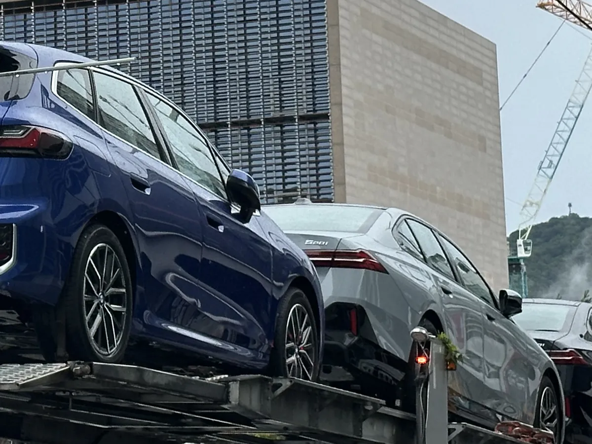 카캐리어 위층에 실린 파란 BMW 2시리즈 액티브 투어러와 회색 5시리즈