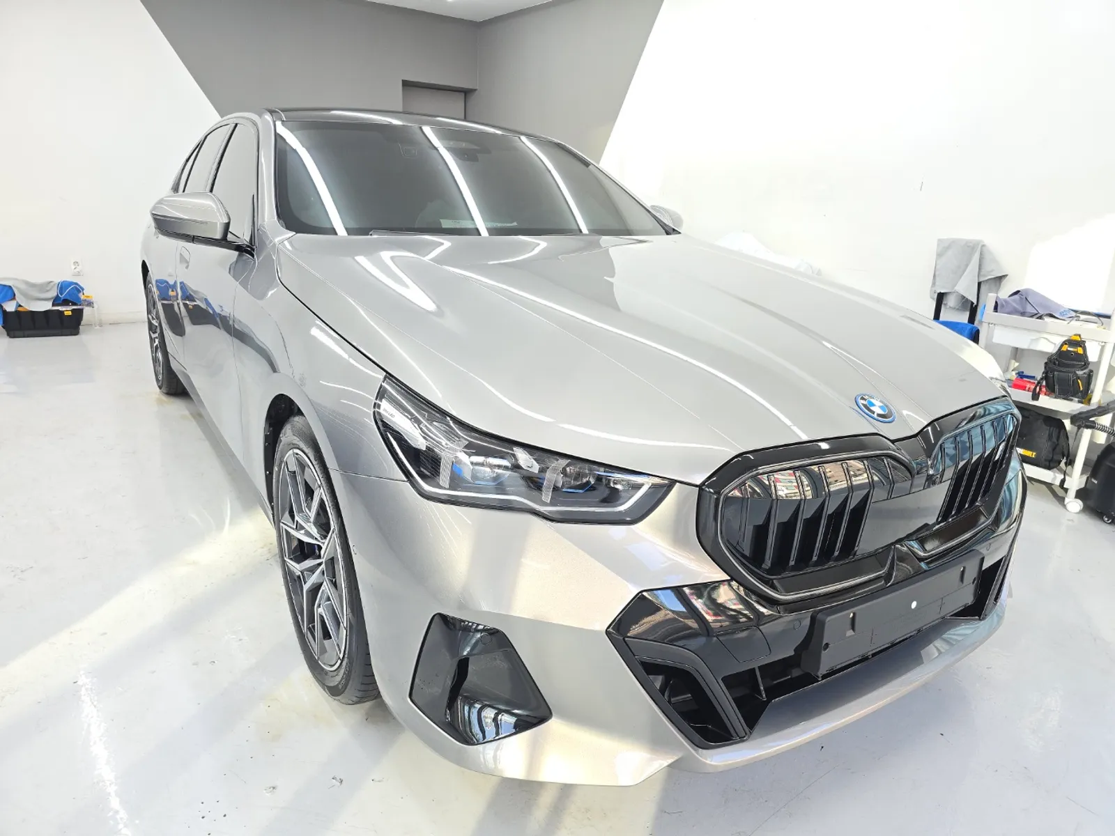 시공을 마치고 전시장 실내에 세워진 흰색 BMW 5시리즈 앞모습