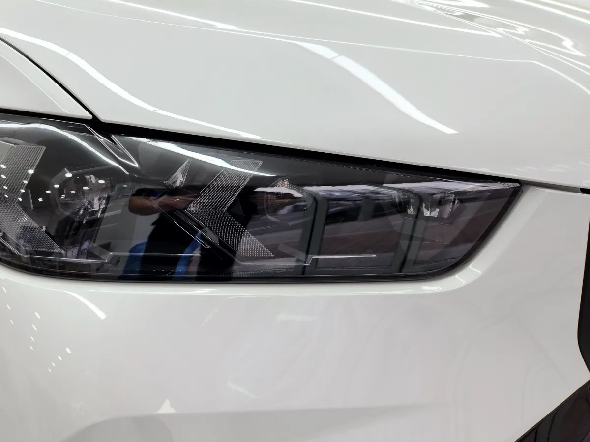 필름을 붙인 흰색 BMW 헤드램프 클로즈업