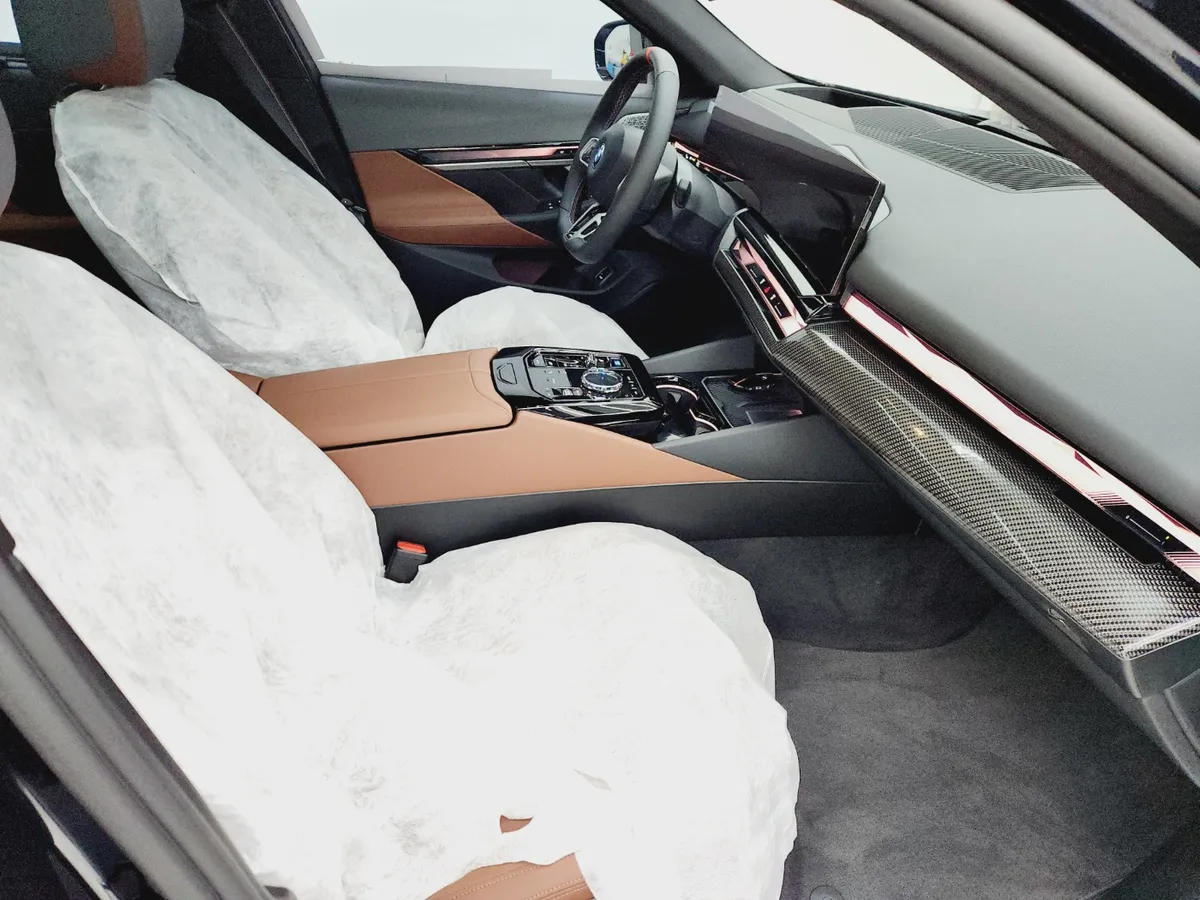 시트와 콘솔을 흰 보호 커버로 덮은 BMW 실내 운전석